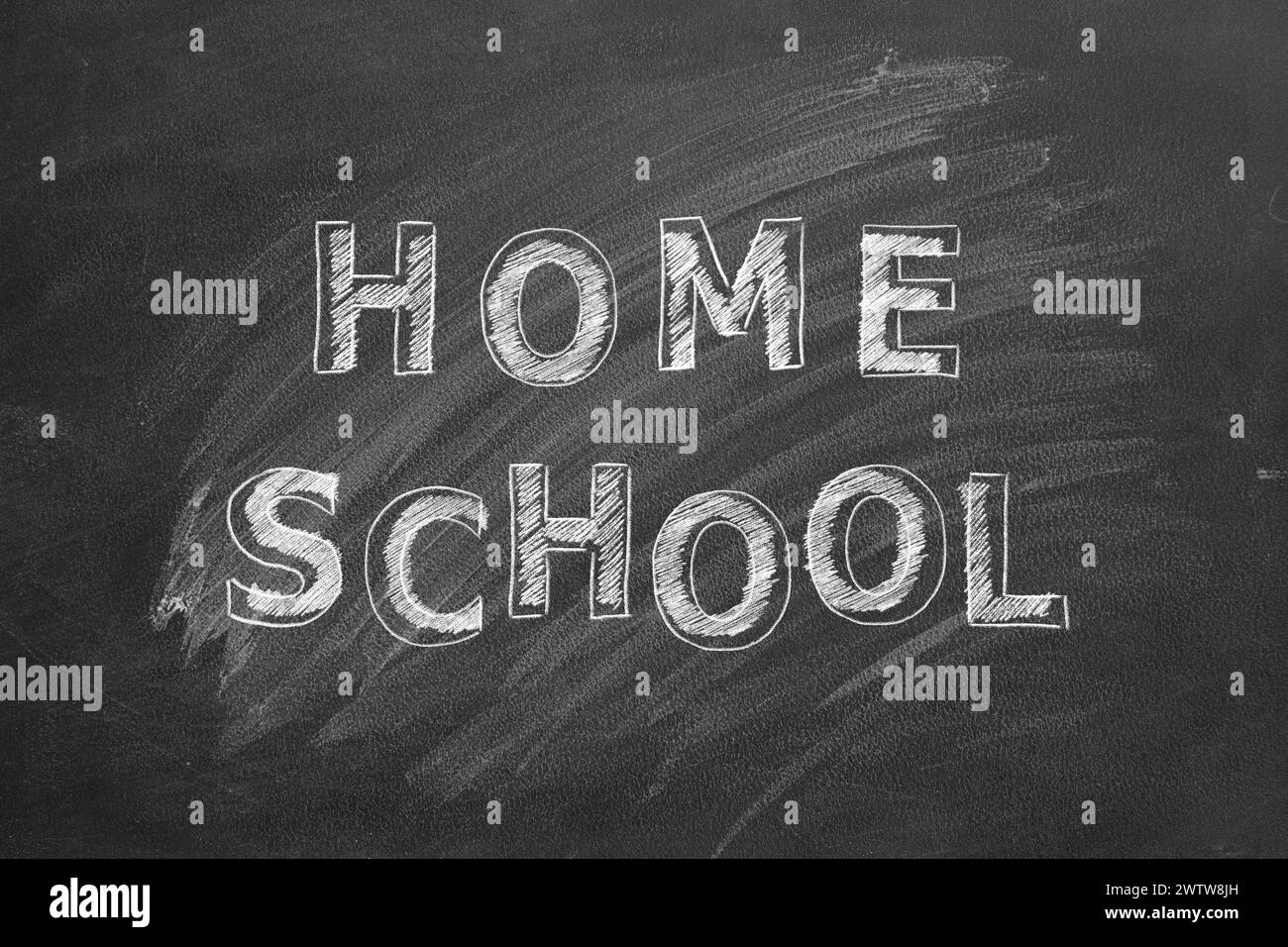 Testo disegno a mano Home School su lavagna nera. Foto Stock