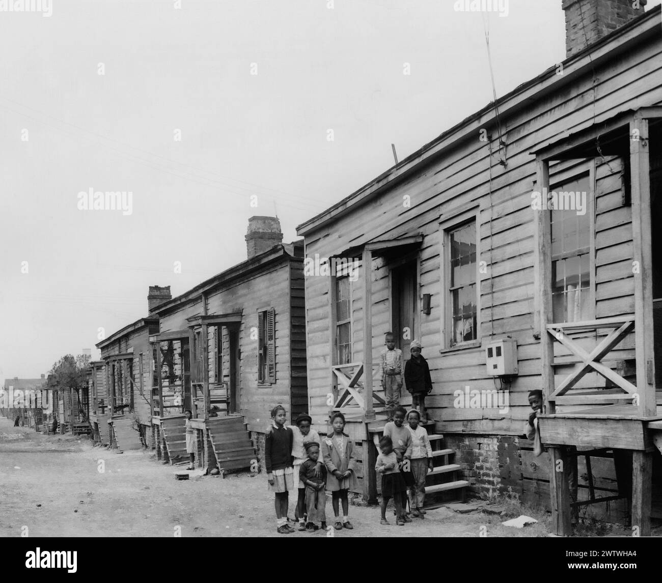 Un gruppo di bambini in Indian Spring Lane a Savannah, Georgia, una delle strade peggiori della città è una fila di baracche, pochissimi dei quali hanno acqua corrente all'interno della casa e molti hanno bagni esterni Foto Stock