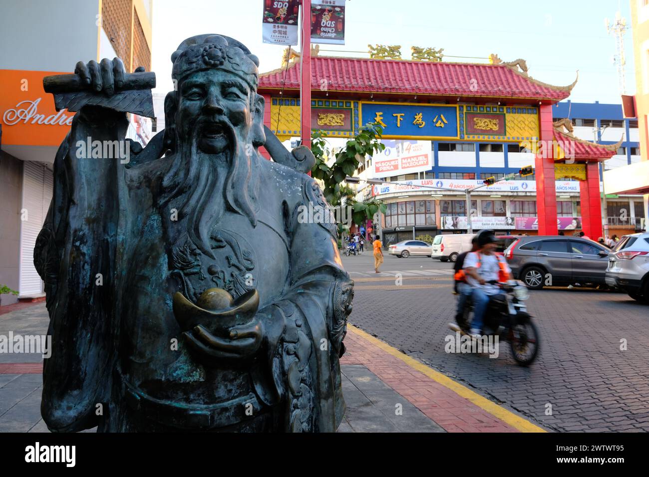 La statua del Dio della ricchezza con una porta ad arco cinese sullo sfondo nella Chinatown di Santo Domingo. Santo Domingo. Repubblica Dominicana Foto Stock