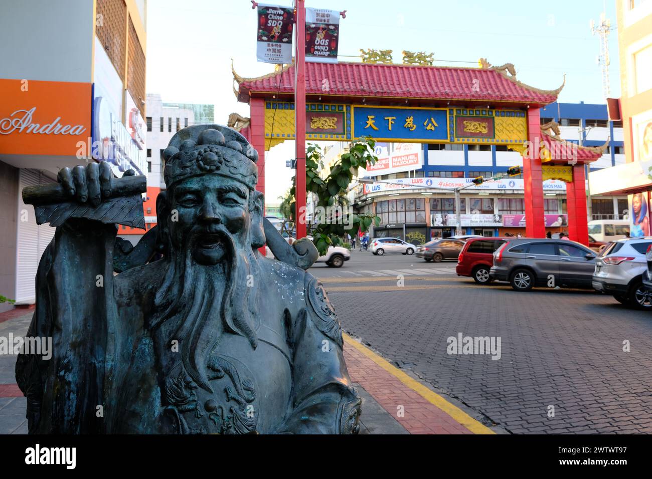 La statua del Dio della ricchezza con una porta ad arco cinese sullo sfondo nella Chinatown di Santo Domingo. Santo Domingo. Repubblica Dominicana Foto Stock