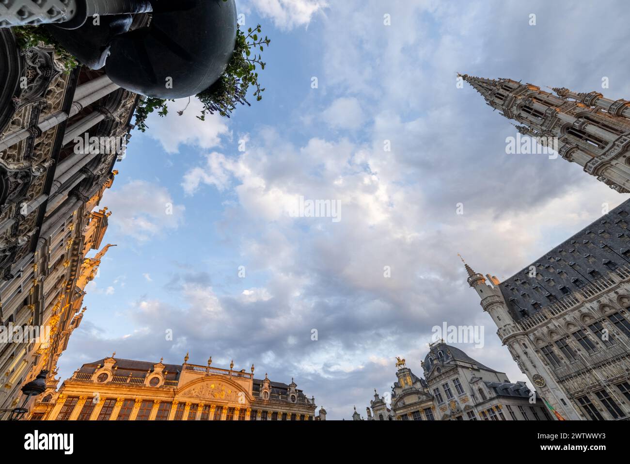 Bruxelles, Belgio, 23 giugno 2023, questa foto dall'angolo basso offre una vista mozzafiato delle facciate ornate e delle torri svettanti della Grand Place di Bruxelles, incorniciate da un cielo dinamico con un leggero filtraggio della luce serale. Spazia il cielo sulle storiche torri della Grand Place a Bruxelles. Foto di alta qualità Foto Stock