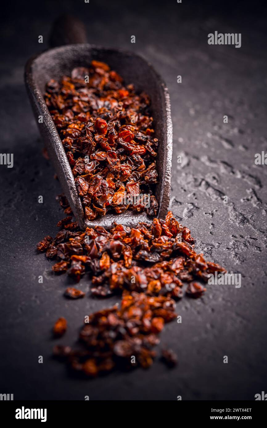 Berberi secchi organici e paletta su terreno nero Foto Stock