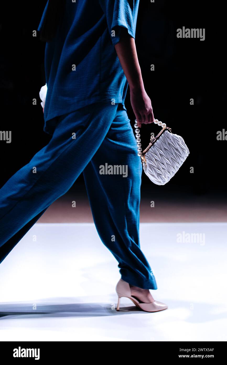 Pochette piccola bianca a mano da donna, blusa blu e pantaloni. La moda moderna ed elegante da donna Foto Stock