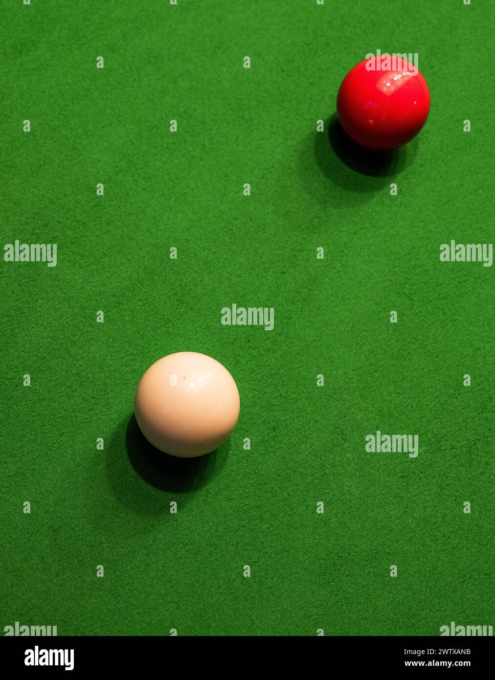 Palle da snooker rosse e bianche sul baize verde di un tavolo da snooker; una palla da cue e una palla da oggetti. Foto Stock
