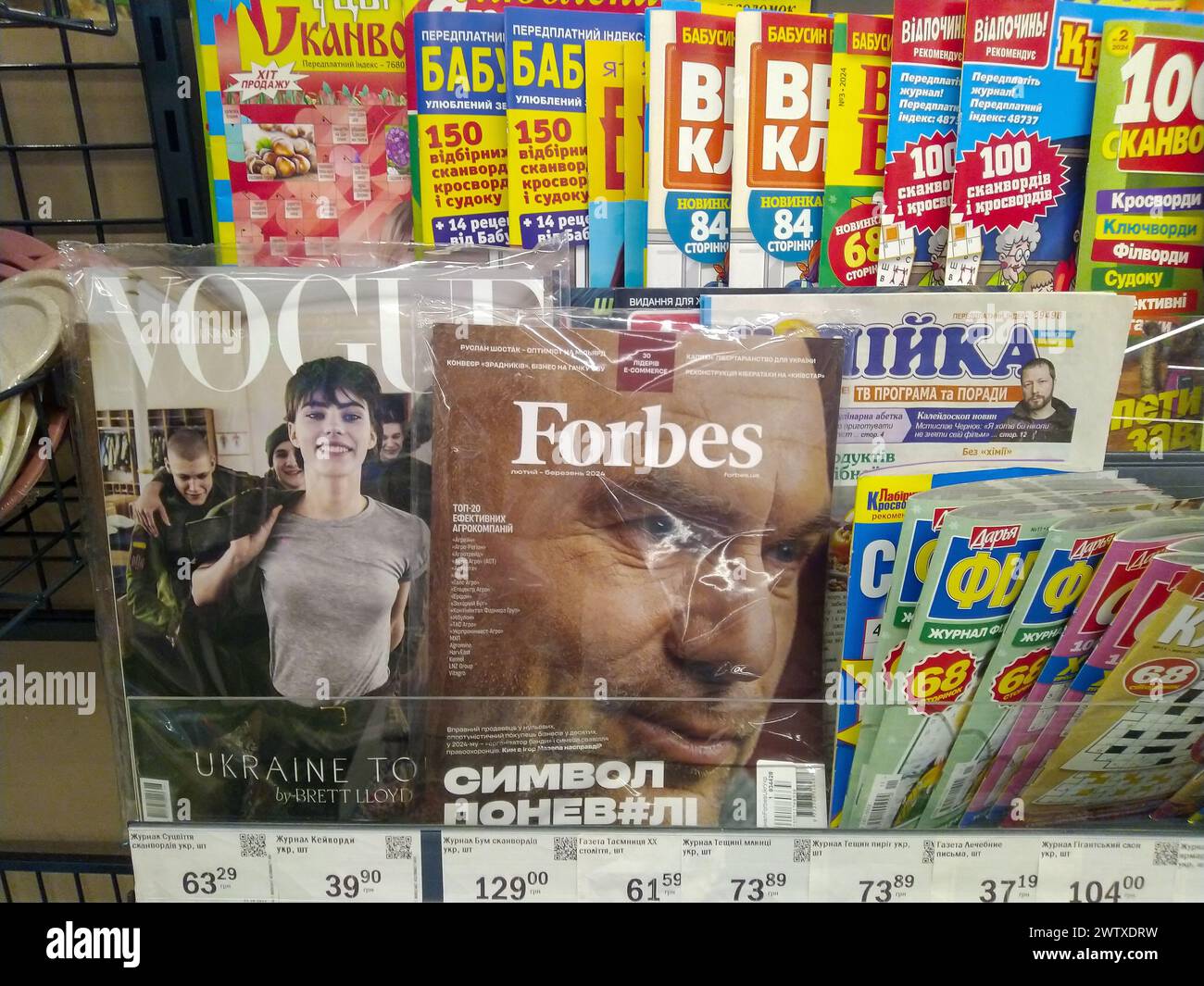 Un banco in un negozio con giornali e periodici. Riviste VOGUE e Forbes. Ucraina, Kiev - 18 marzo 2024. Foto Stock