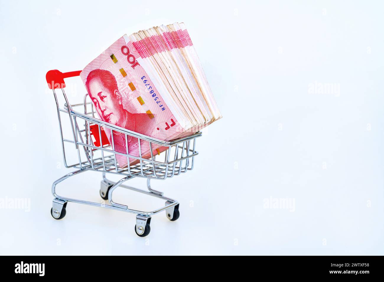 Carrello con 100 Yuan cinesi all'interno su sfondo bianco. Concetto di denaro ed economia del consumatore. Foto Stock
