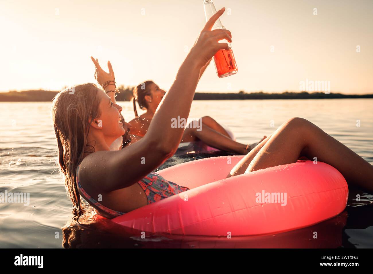 Gruppo di amici che si godono una giornata estiva nuotando al lago. Foto Stock