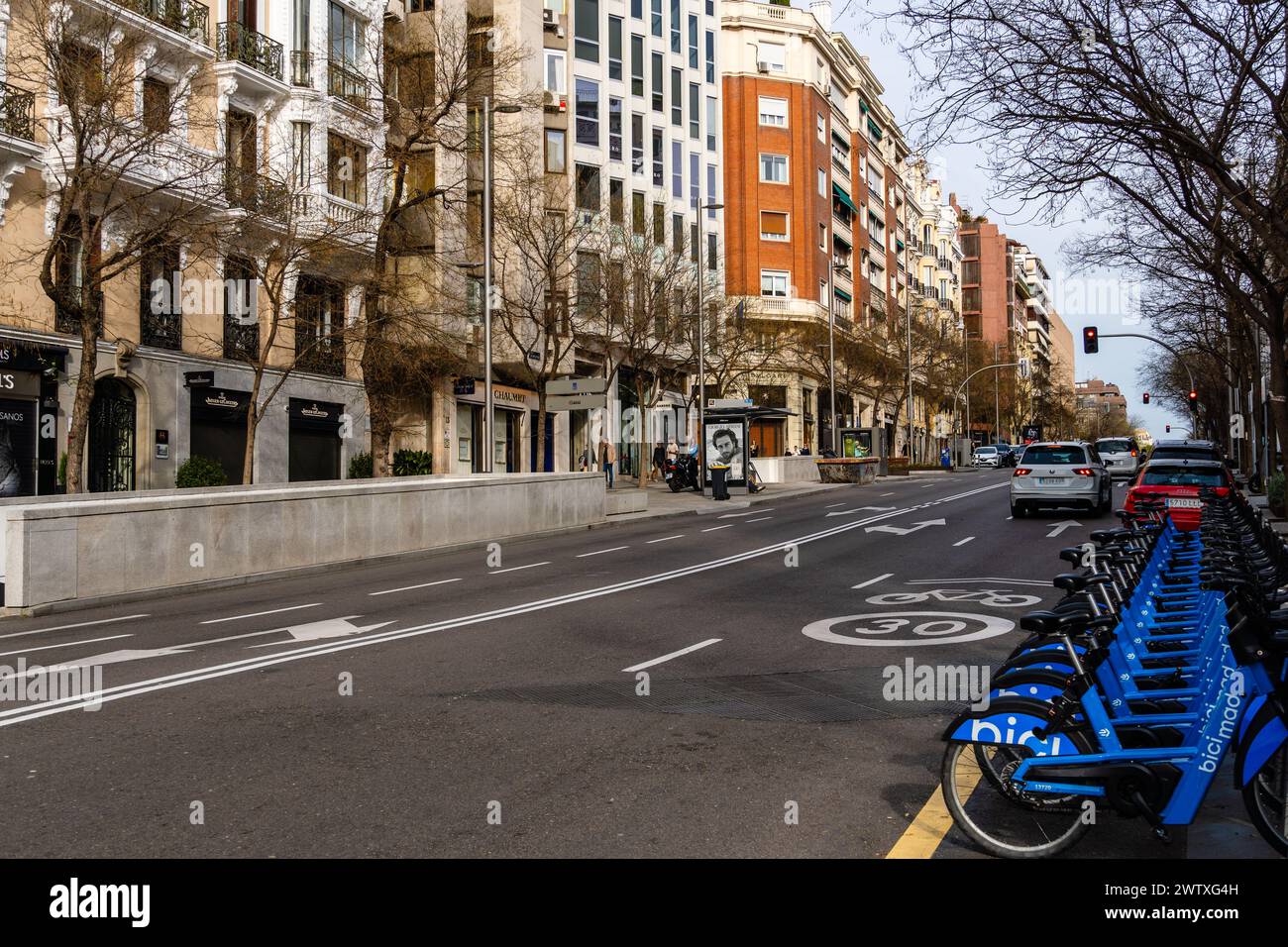 Madrid, Spagna - 17 marzo 2024: Via Ortega y Gasset nel distretto di Salamanca. Area commerciale di lusso. Parcheggio per biciclette a noleggio Foto Stock