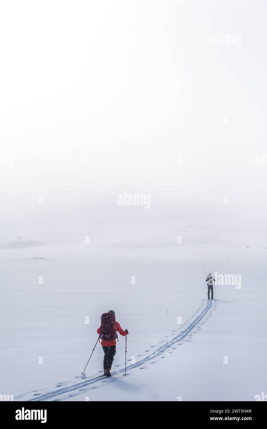 Due sciatori in condizioni di nebbia tra le montagne della Norvegia Foto Stock