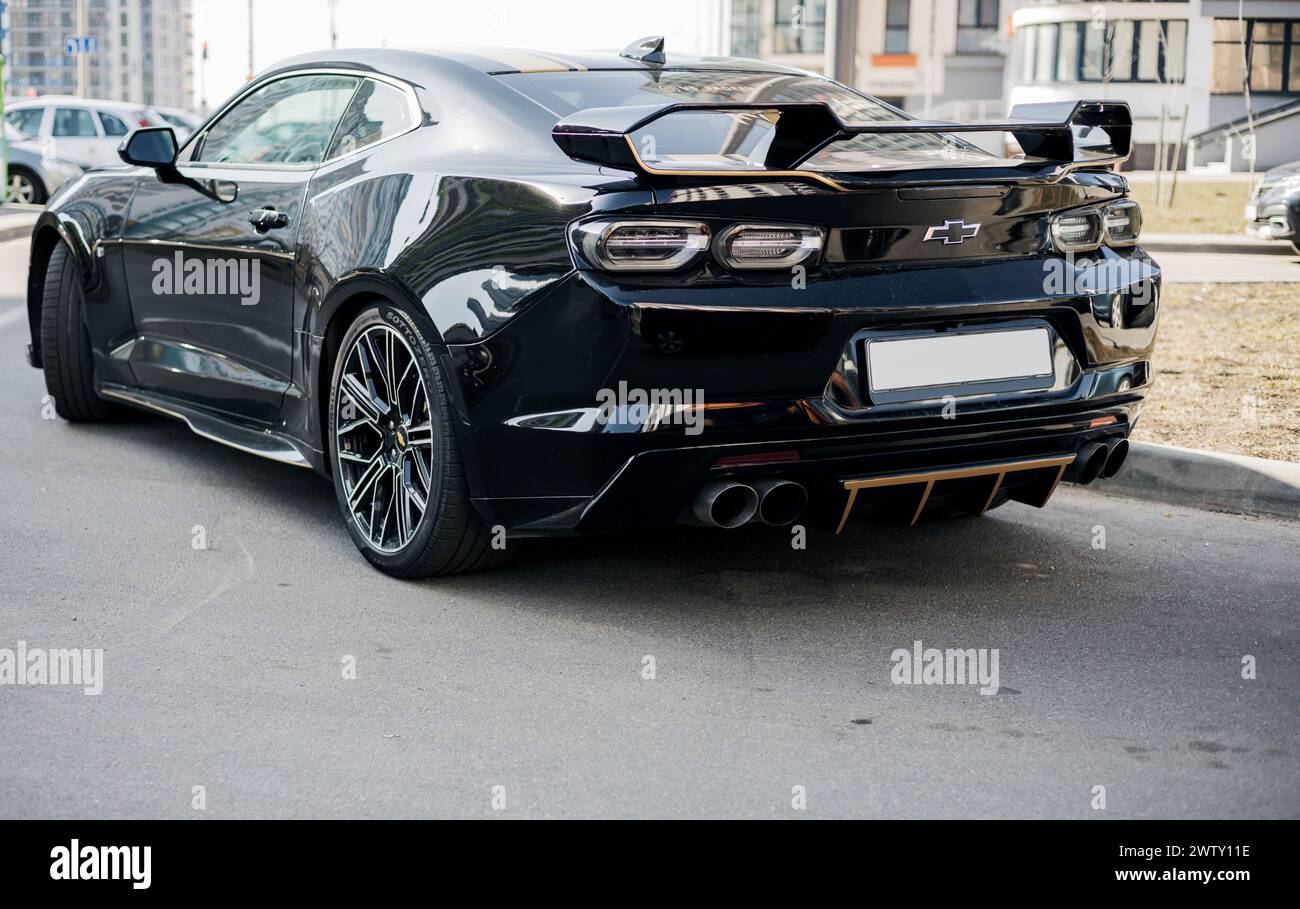 Minsk, Bielorussia, 20 marzo 2024 - Vista posteriore auto sportiva nera di lusso - la Chevrolet Camaro è parcheggiata per strada nelle giornate di sole Foto Stock