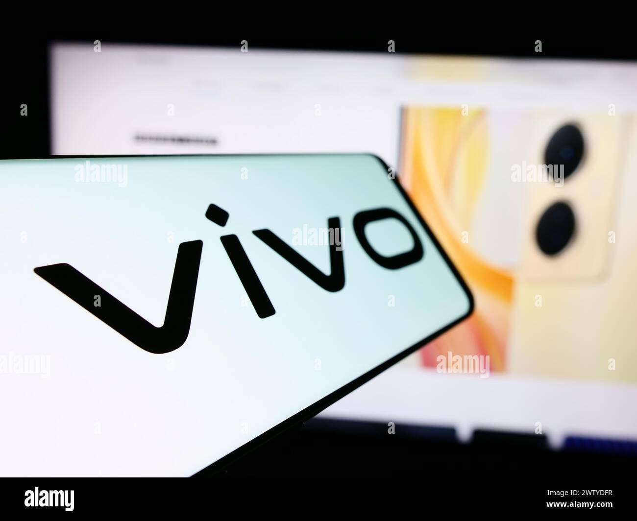 Telefono cellulare con logo della società cinese vivo Communication Technology Co. Ltd. Di fronte al sito Web aziendale. Mettere a fuoco la parte sinistra del display del telefono. Foto Stock