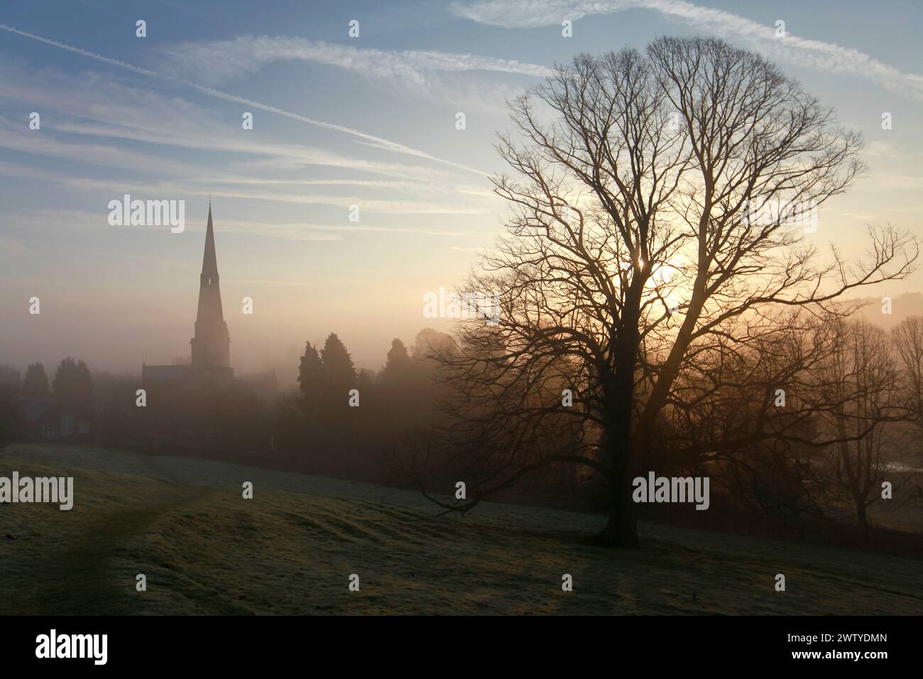 01/03/2012..Un'alba nebbiosa incornicia la chiesa parrocchiale di St Oswald ad Ashbourne, Derbyshire. La sua guglia da 212 piedi fu definita da George Eliot come "fi" Foto Stock