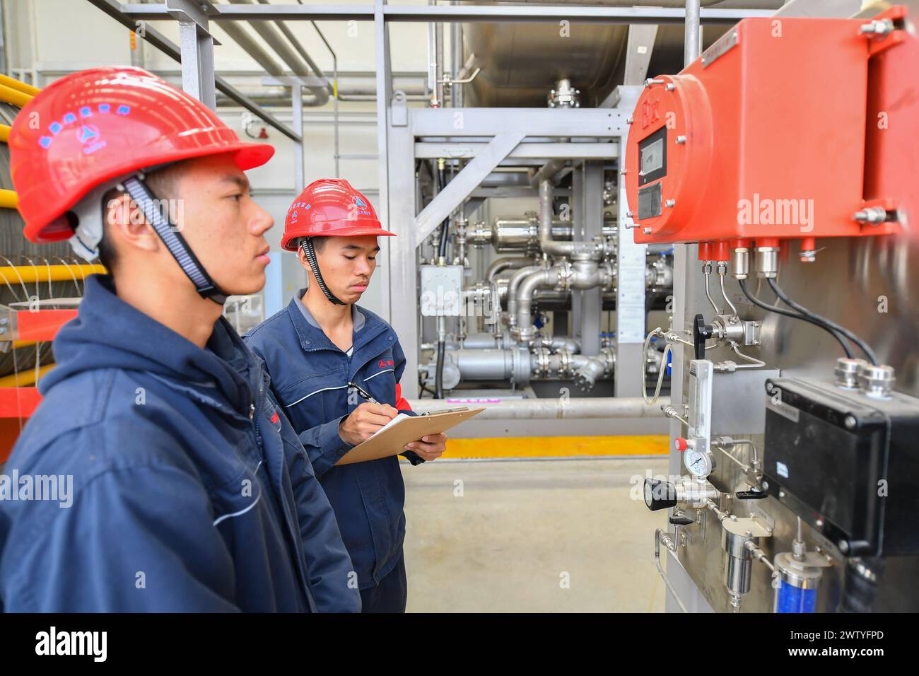 Changsha, la provincia cinese di Hunan. 20 marzo 2024. I lavoratori del personale ispezionano l'area di produzione dell'idrogeno presso la stazione di produzione e distribuzione dell'idrogeno del Sany Group a Changsha, capitale della provincia di Hunan della Cina centrale, 20 marzo 2024. Situata nella zona di sviluppo economico di Changsha, la costruzione della stazione di produzione e distribuzione di idrogeno Sany è stata completata con capacità di servizio di base. Con una capacità giornaliera non inferiore a due tonnellate di idrogeno al giorno, la stazione può riempire quattro veicoli alimentati a idrogeno contemporaneamente. Crediti: Chen Zeguo/Xinhua/Alamy Live News Foto Stock