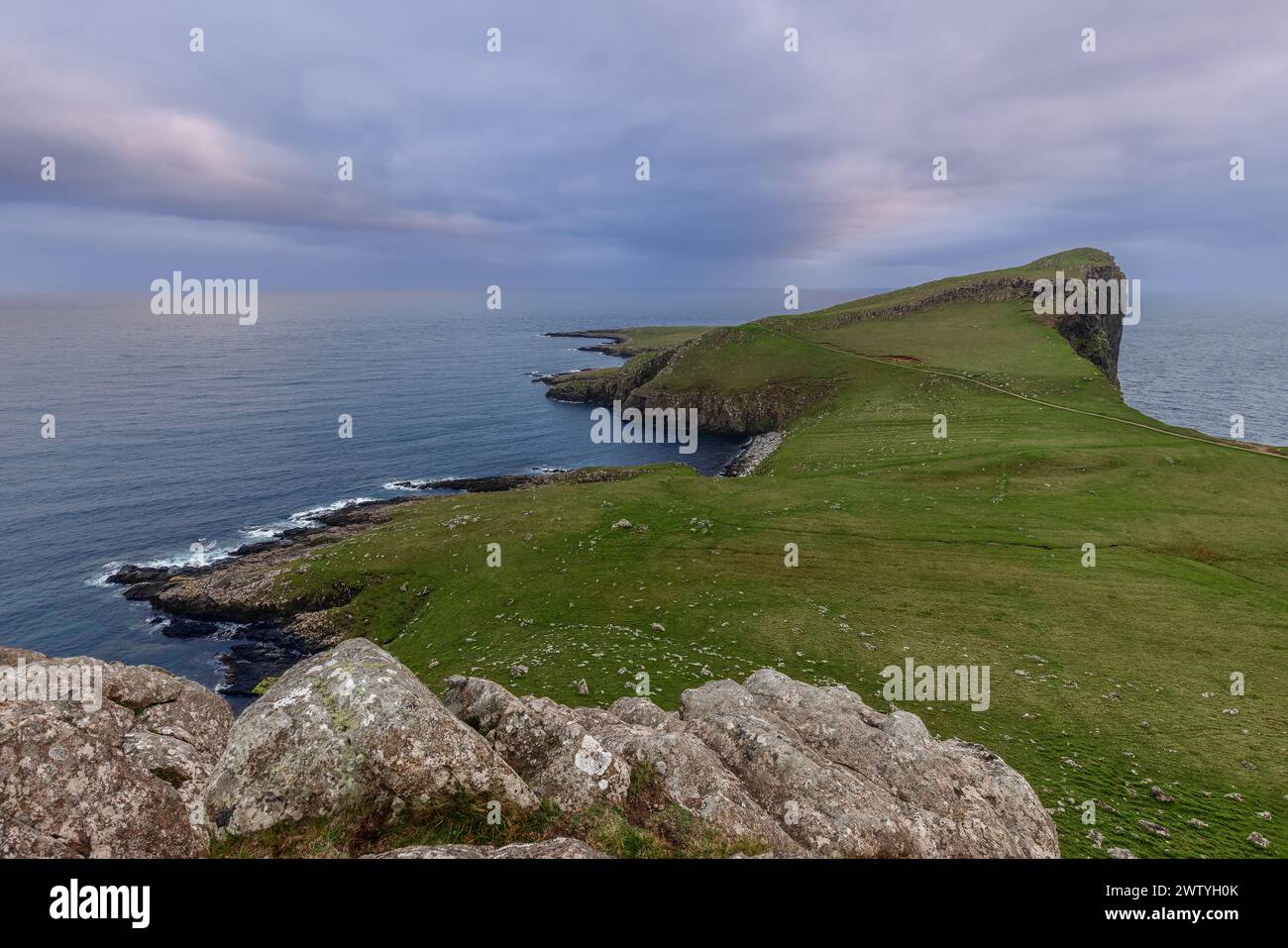 La spettacolare scogliera di Neist sull'isola di Skye si affaccia sull'oceano, sotto un cielo morbido e color pastello Foto Stock