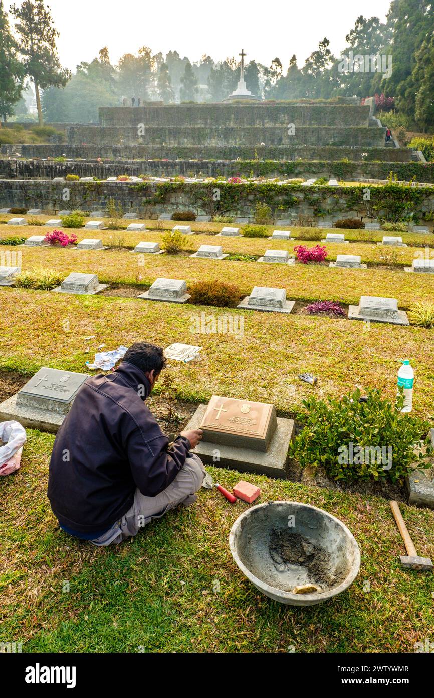 Membro dello staff che mantiene una pietra miliare al Commonwealth War Cemetery di Kohima, Nagaland, India nord-orientale Foto Stock