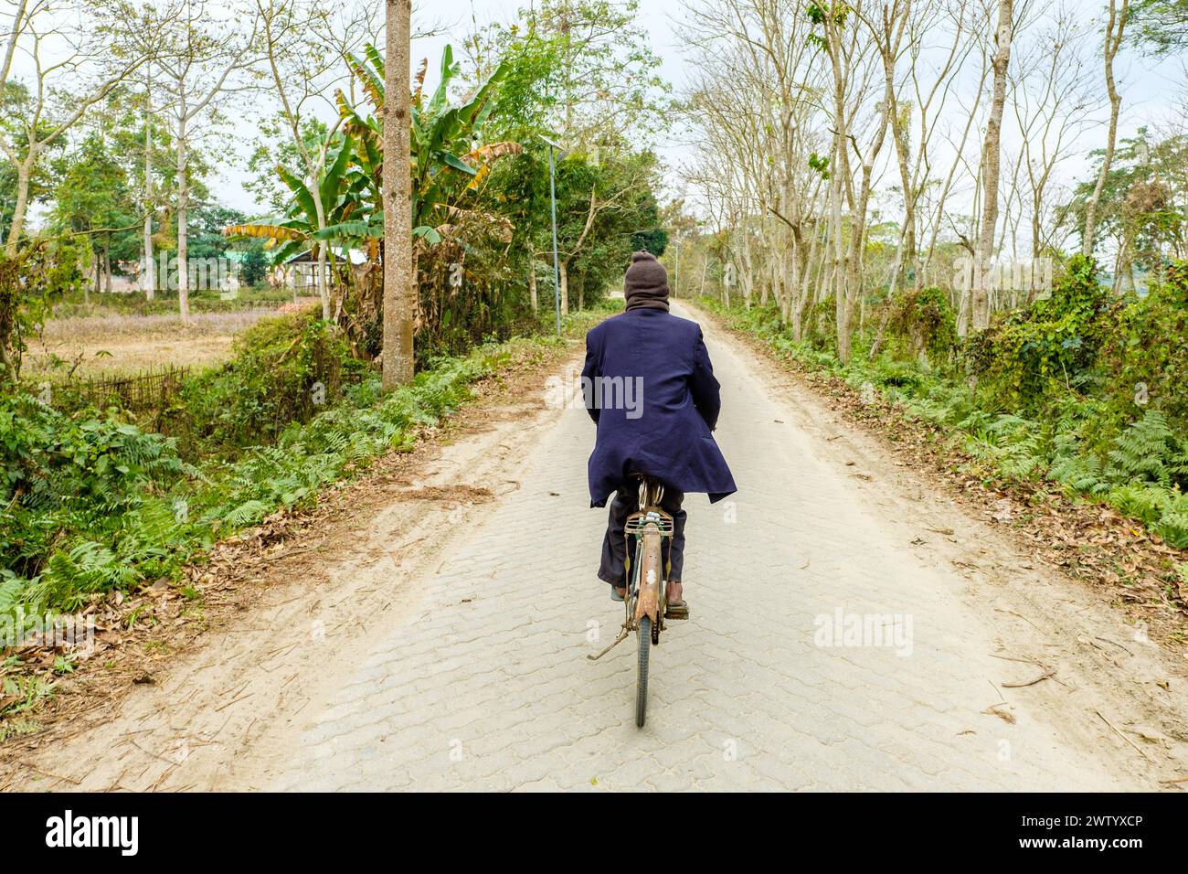 Un uomo anziano in bicicletta sull'isola di Majuli, Assam, India Foto Stock
