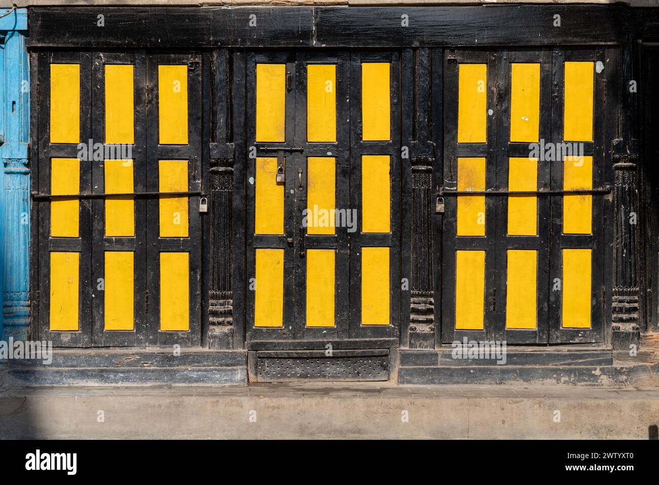 Grandi porte in metallo gialle con telai neri sul lato di una struttura Foto Stock