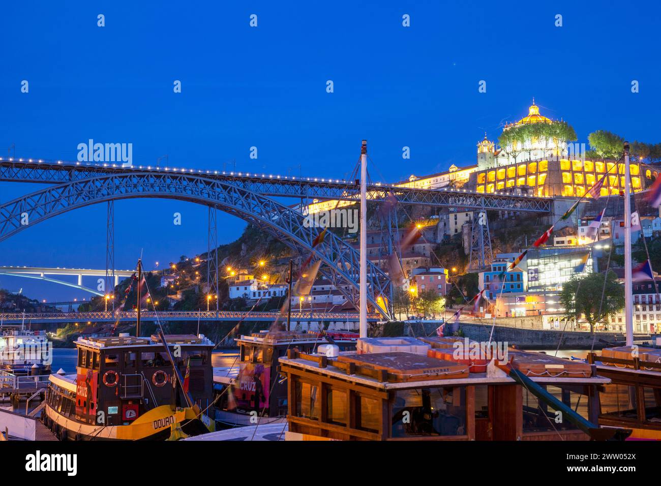 Portogallo, Porto, quartiere di Ribeira; guardando attraverso il fiume Douro di notte verso Vila Nova de Gaia e il ponte Luís I. Foto Stock