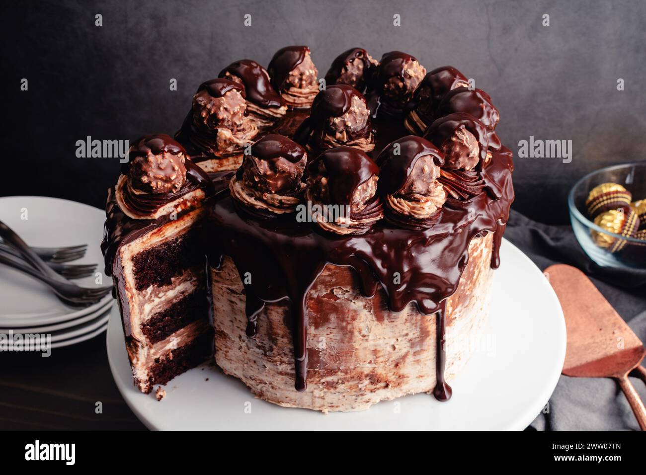 Torta al cioccolato alle nocciole con ganache al cioccolato e caramelle alle nocciole: Torta a strati di cioccolato con glassa di crema alle nocciole effetto acquerello Foto Stock