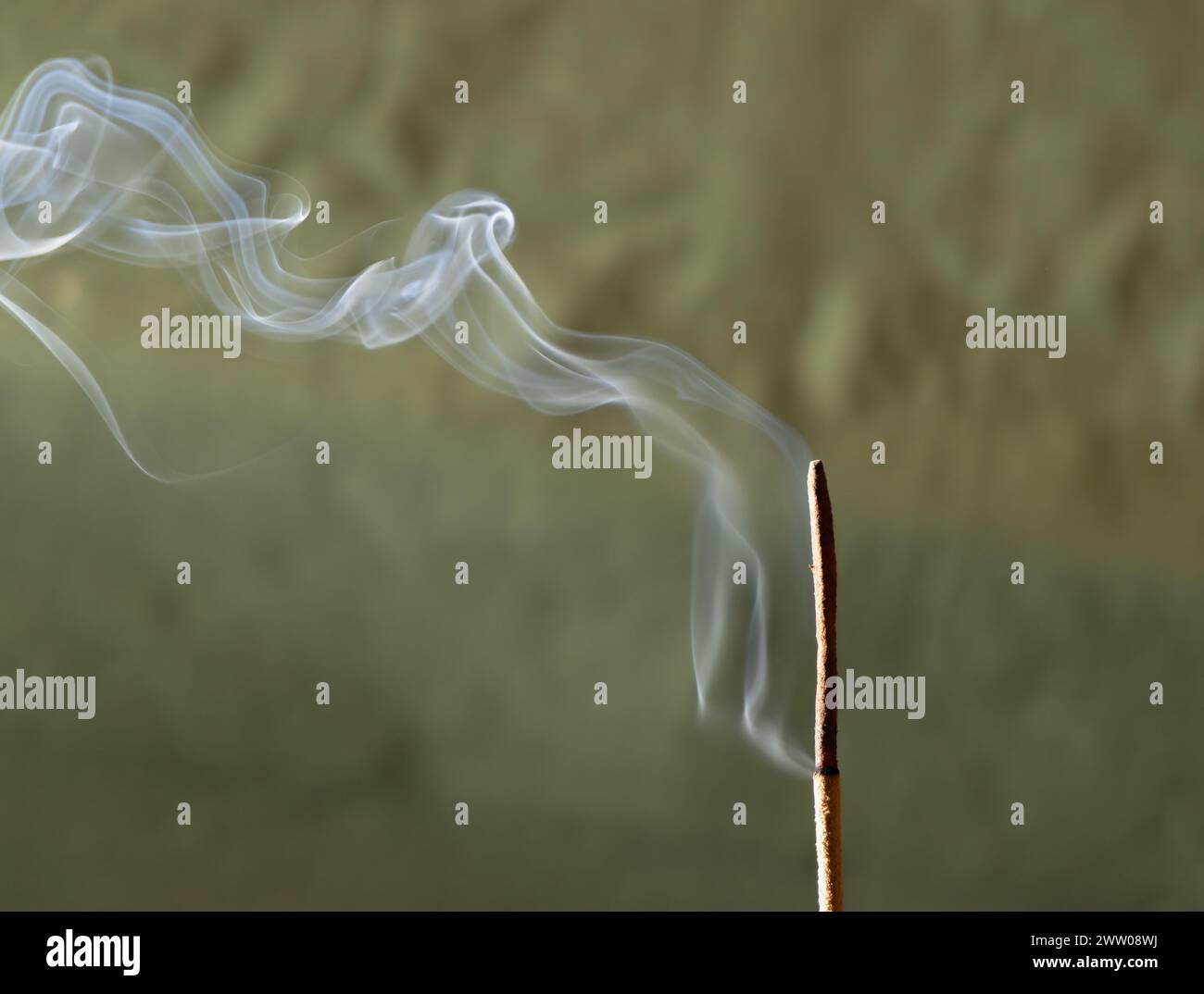 Fumo proveniente dall'incenso che gira su uno sfondo verde. Foto Stock