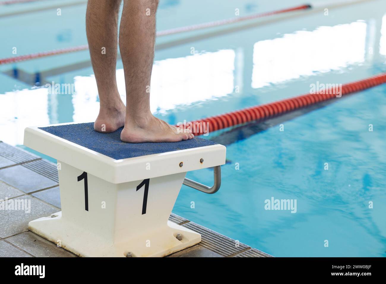 Una persona si trova su un blocco d'immersione, etichettato con il numero uno, con spazio per le copie Foto Stock