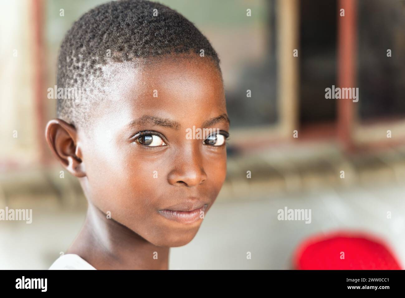 ritratto di una bella ragazza africana con i capelli corti, in piedi davanti alla casa Foto Stock