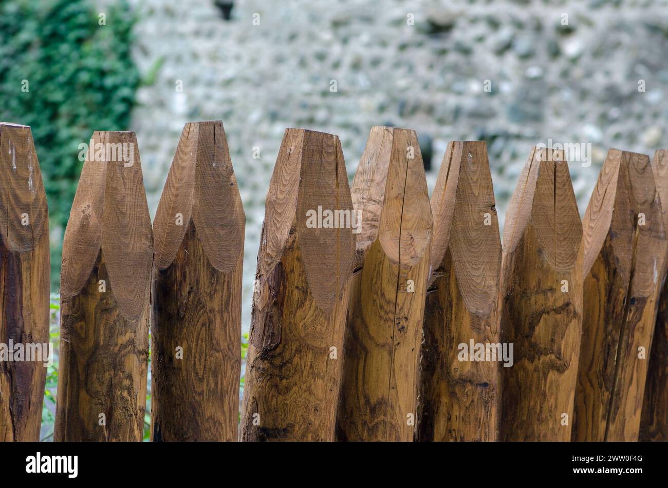 recinzione in legno, per giardini lungo la strada, realizzata con lunghi pali rotondi. sfondo a tema legno, con tronchi trattati per resistere alla pioggia e agli agenti atmosferici. Foto Stock