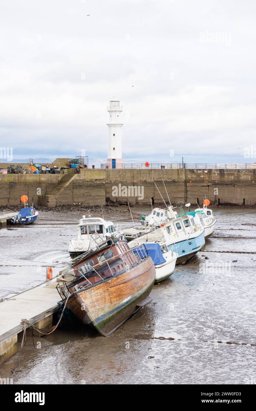 Newhaven, Scozia, Regno Unito - marzo 2024: Il faro del porto di Newhaven si trova alla fine della frangiflutti con recinzioni metalliche su ciascun lato. Foto Stock