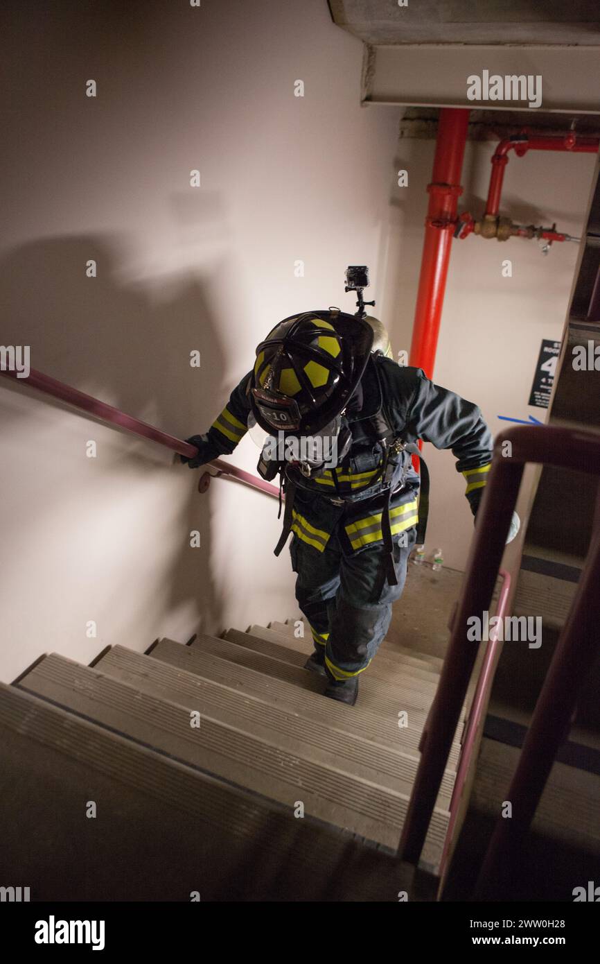 Un vigile del fuoco sale le scale Foto Stock