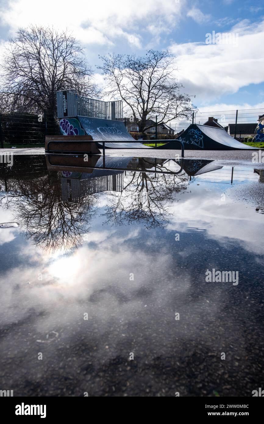 Rampa vuota per skateboard che si riflette in una pozza di acqua piovana Foto Stock