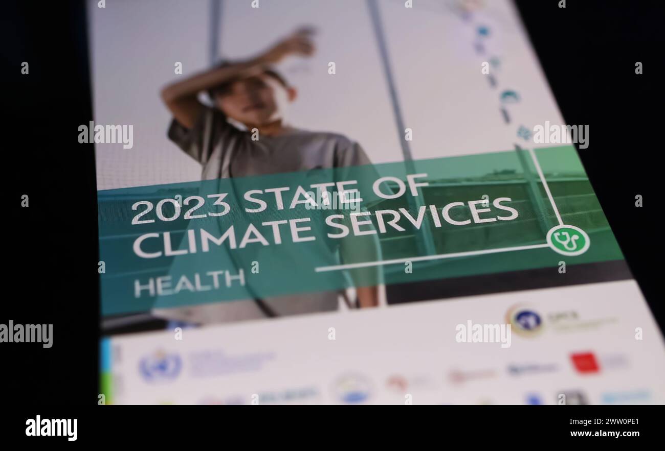 Viersen, Germania - 9 marzo. 2024: Schermo dello smartphone su tastiera del computer con Organizzazione meteorologica Mondiale WMO stato dei servizi sanitari climatici Foto Stock