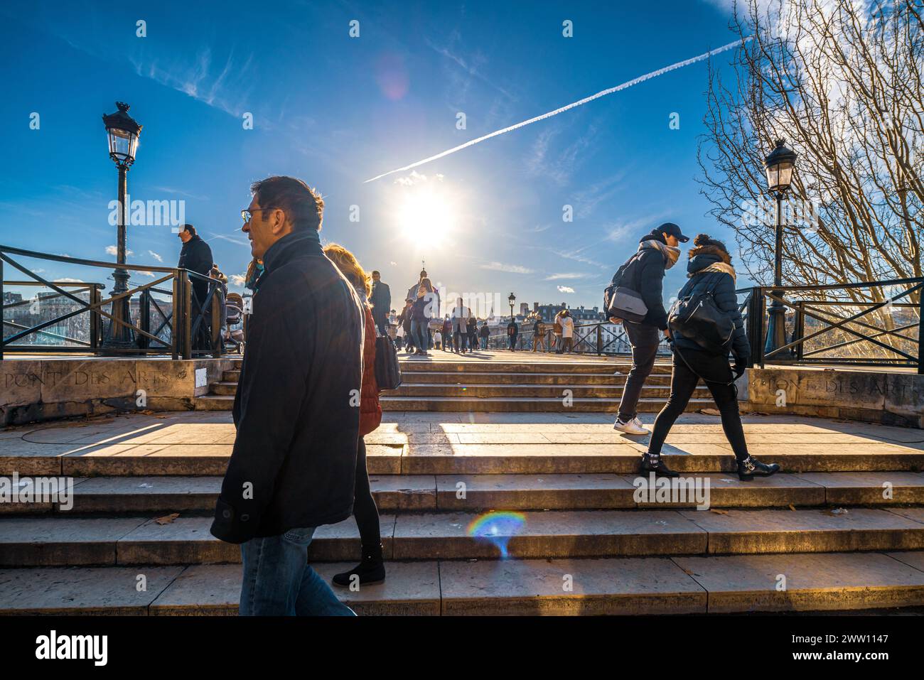 Coppie e singoli si godono l'iconico Pont des Arts di Parigi sotto un cielo limpido. Foto Stock