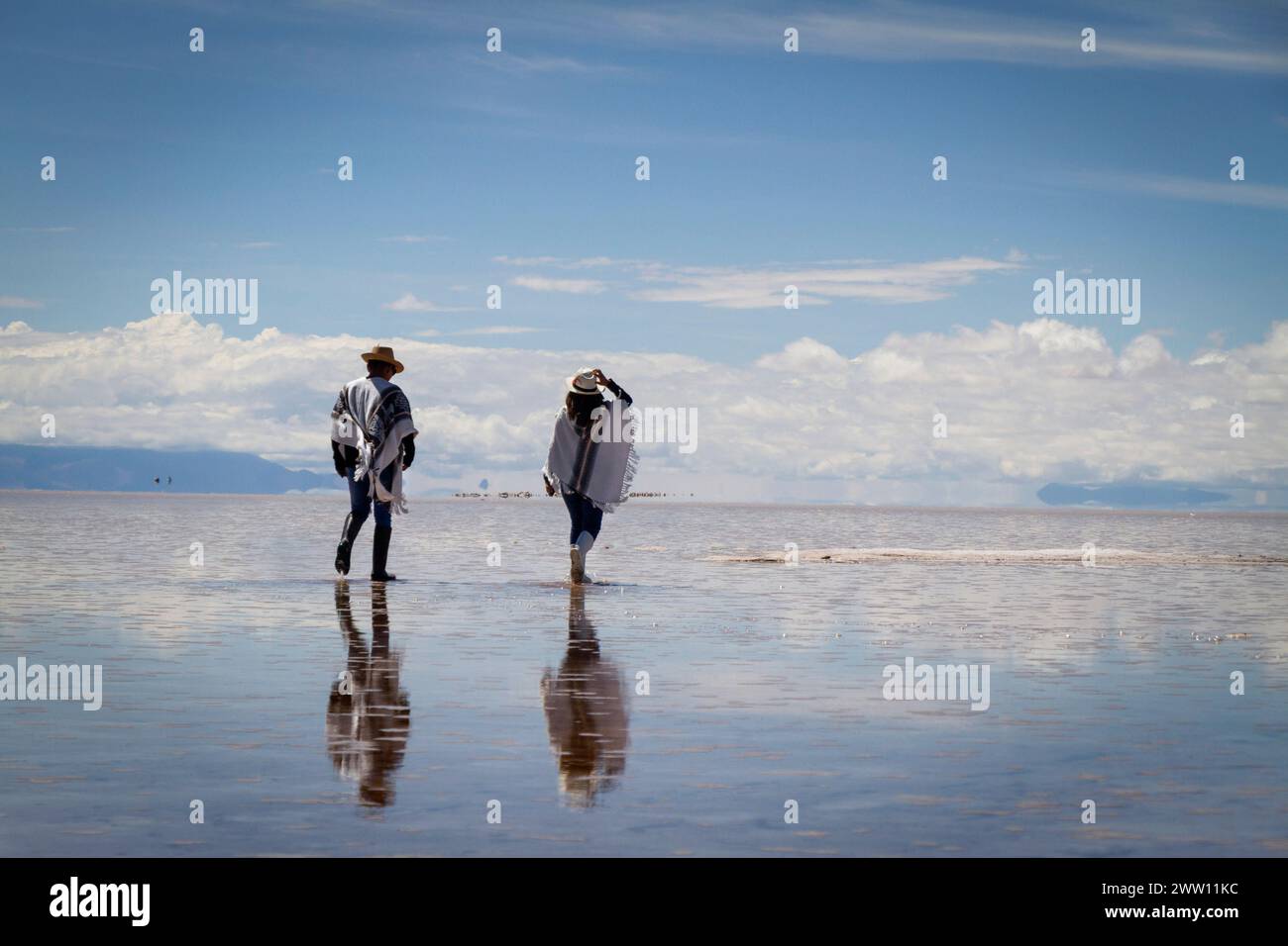 Pareja de jovenes Tourist caminando en salar de Uyuni Bolivia Foto Stock