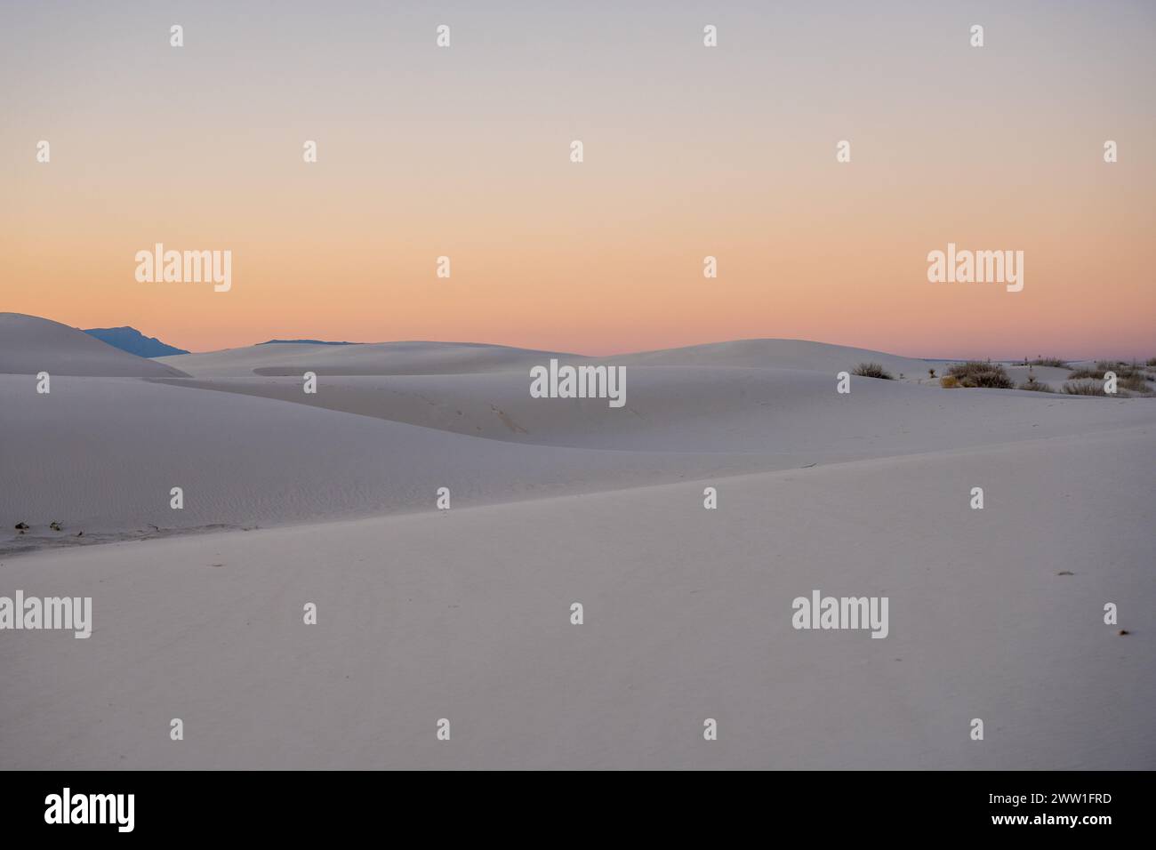 Le dune lisce si infrangono l'una contro l'altra contro i colori del tramonto nel White Sands National Park Foto Stock
