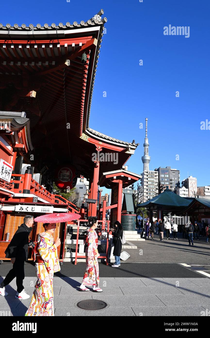 Persone in kimono fuori dal tempio Sensō-ji con Tokyo Skytree sullo sfondo - Asakusa, Taito City, Tokyo, Giappone - 28 febbraio 2024 Foto Stock