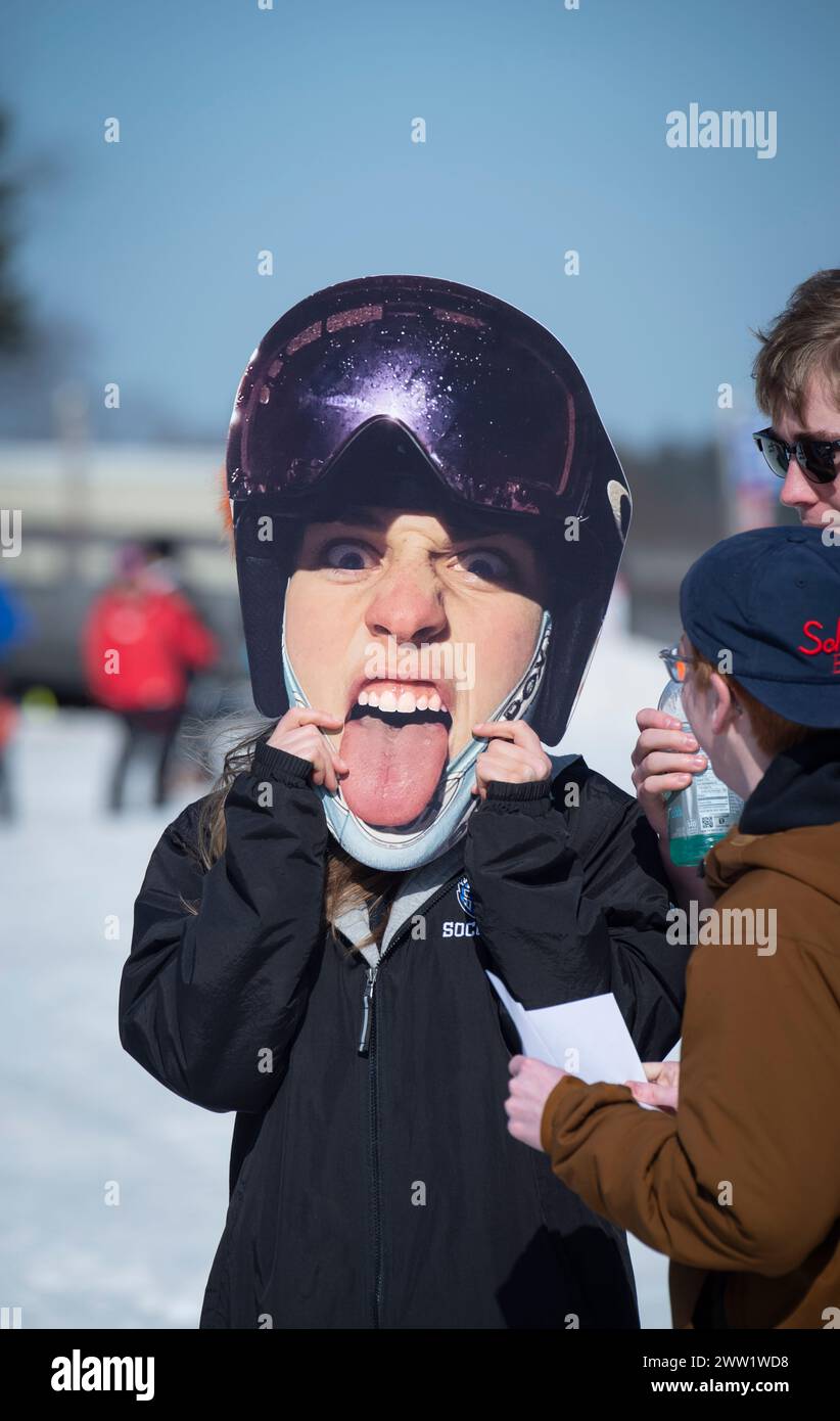 Massachusetts Interscholastic Athletic Association (MIAA) 2024 High School Alpine Ski campionato statale annuale Slalom e Giant Slalom nella zona sciistica di Wachusett Mountain a Princeton, Massachusetts. Un fratello di uno dei piloti tiene un suo ritratto al termine del corso. Foto Stock