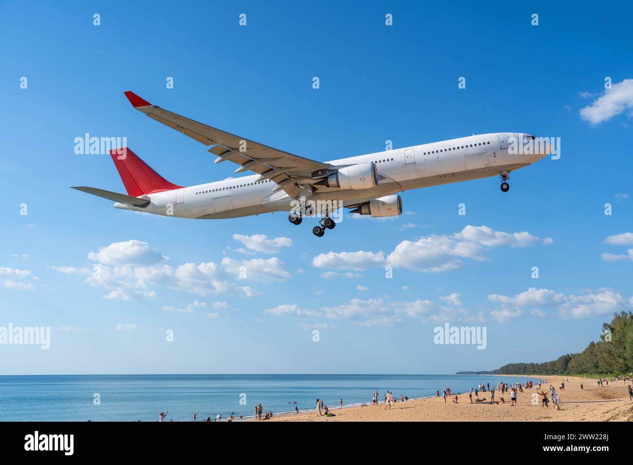 L'aereo atterra sopra la splendida spiaggia con persone sulla spiaggia e sul mare, viaggia. Foto Stock