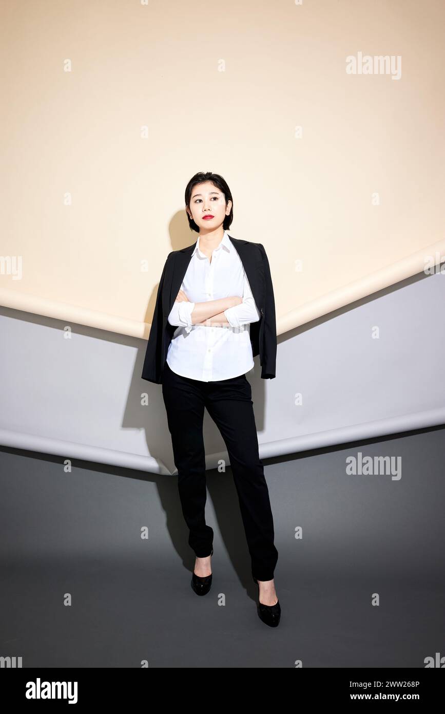 Una donna in camicia bianca e pantaloni neri Foto Stock