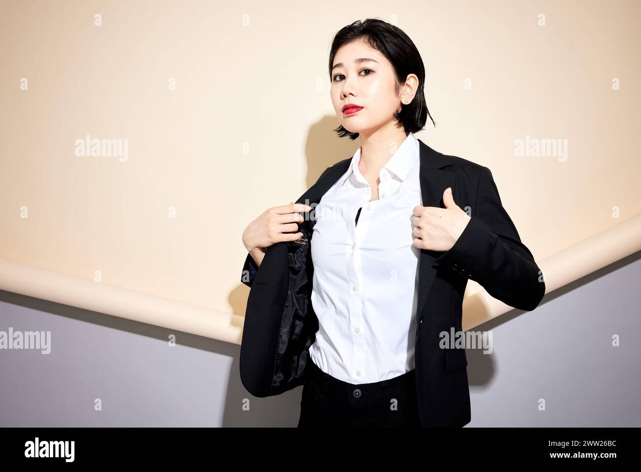 Donna d'affari asiatica in vestito nero e camicia bianca Foto Stock