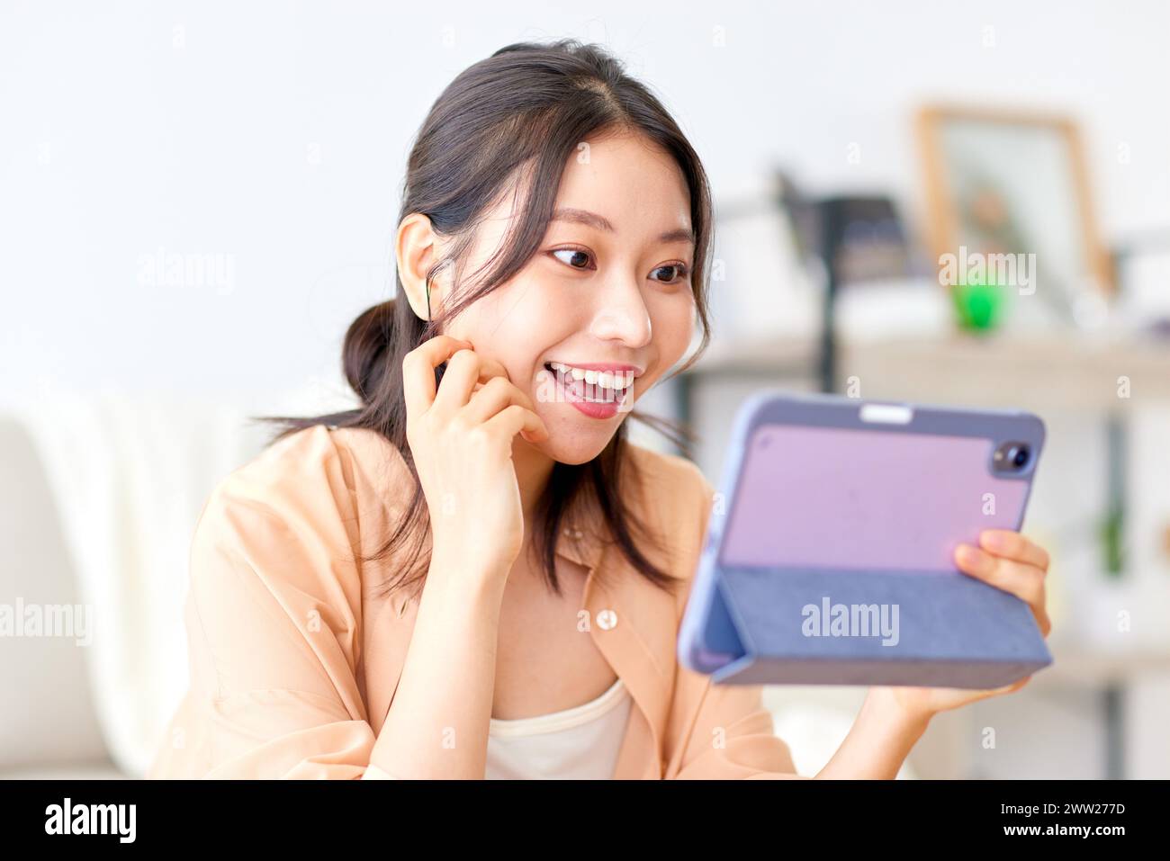 Donna asiatica utilizzando tablet pc a casa Foto Stock