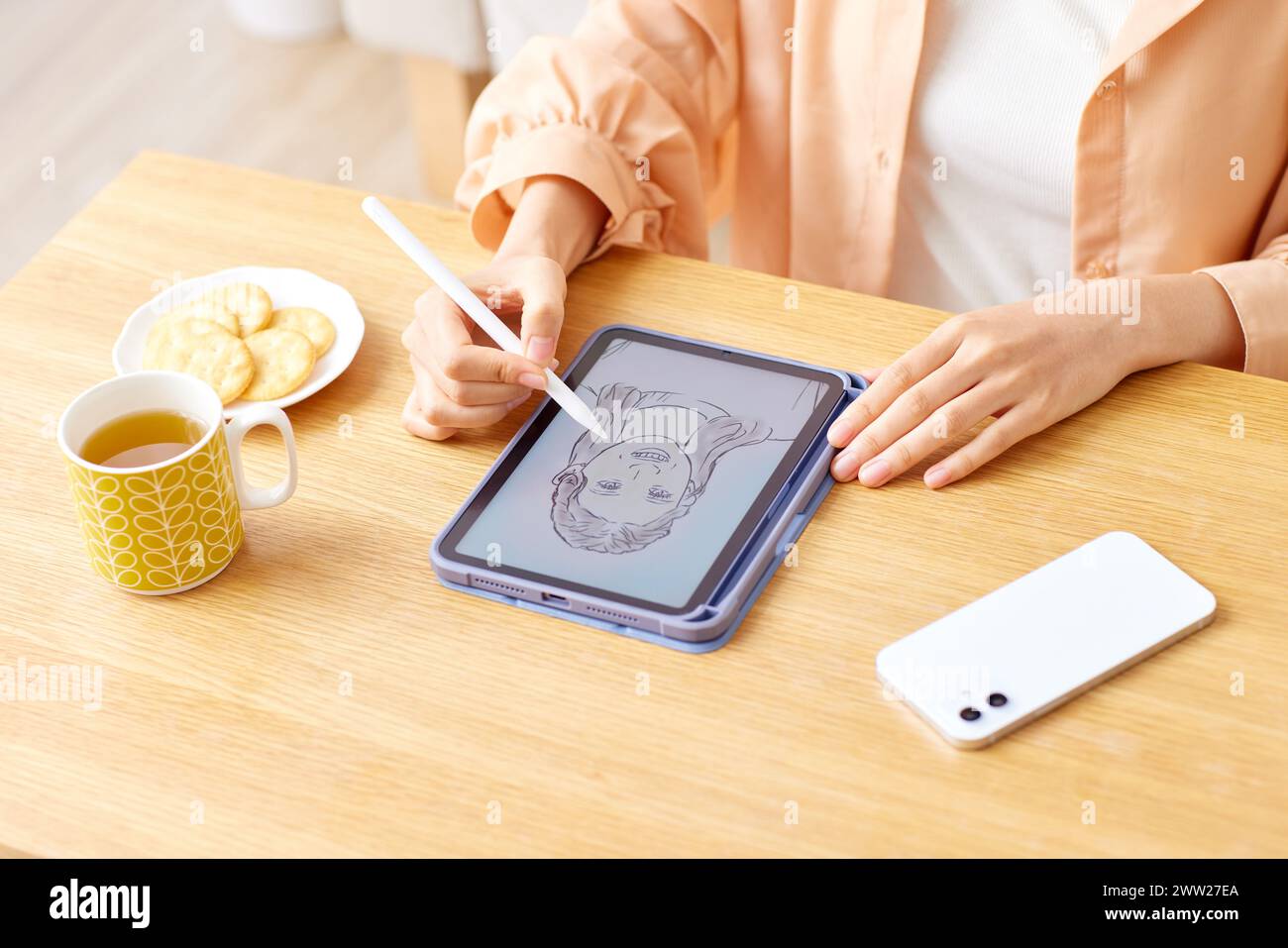 Una donna che disegna su un tablet con una matita Foto Stock