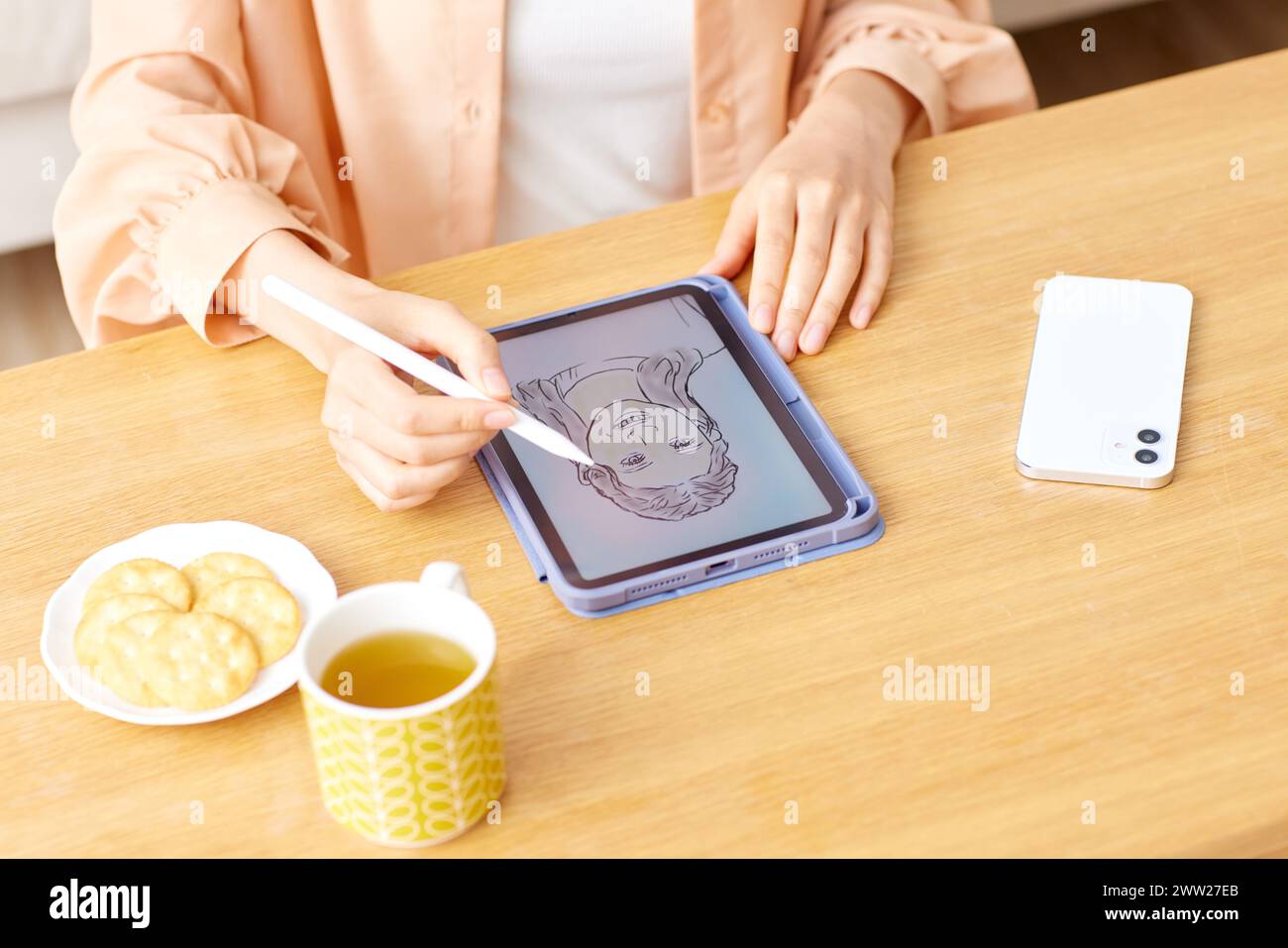 Una donna che disegna su un tablet con una penna Foto Stock