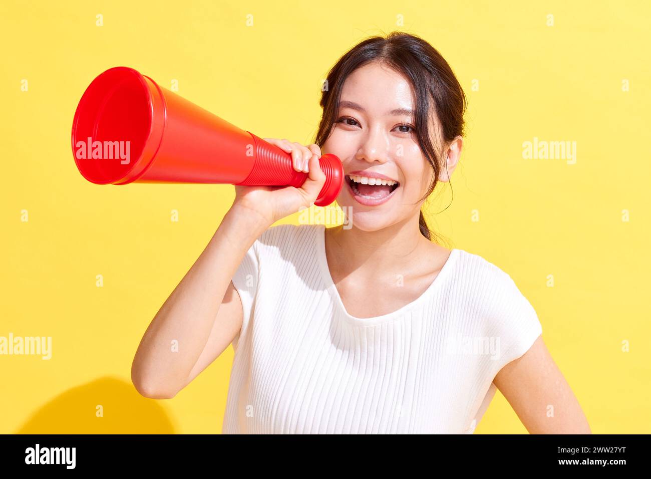 Donna asiatica con un megafono rosso Foto Stock