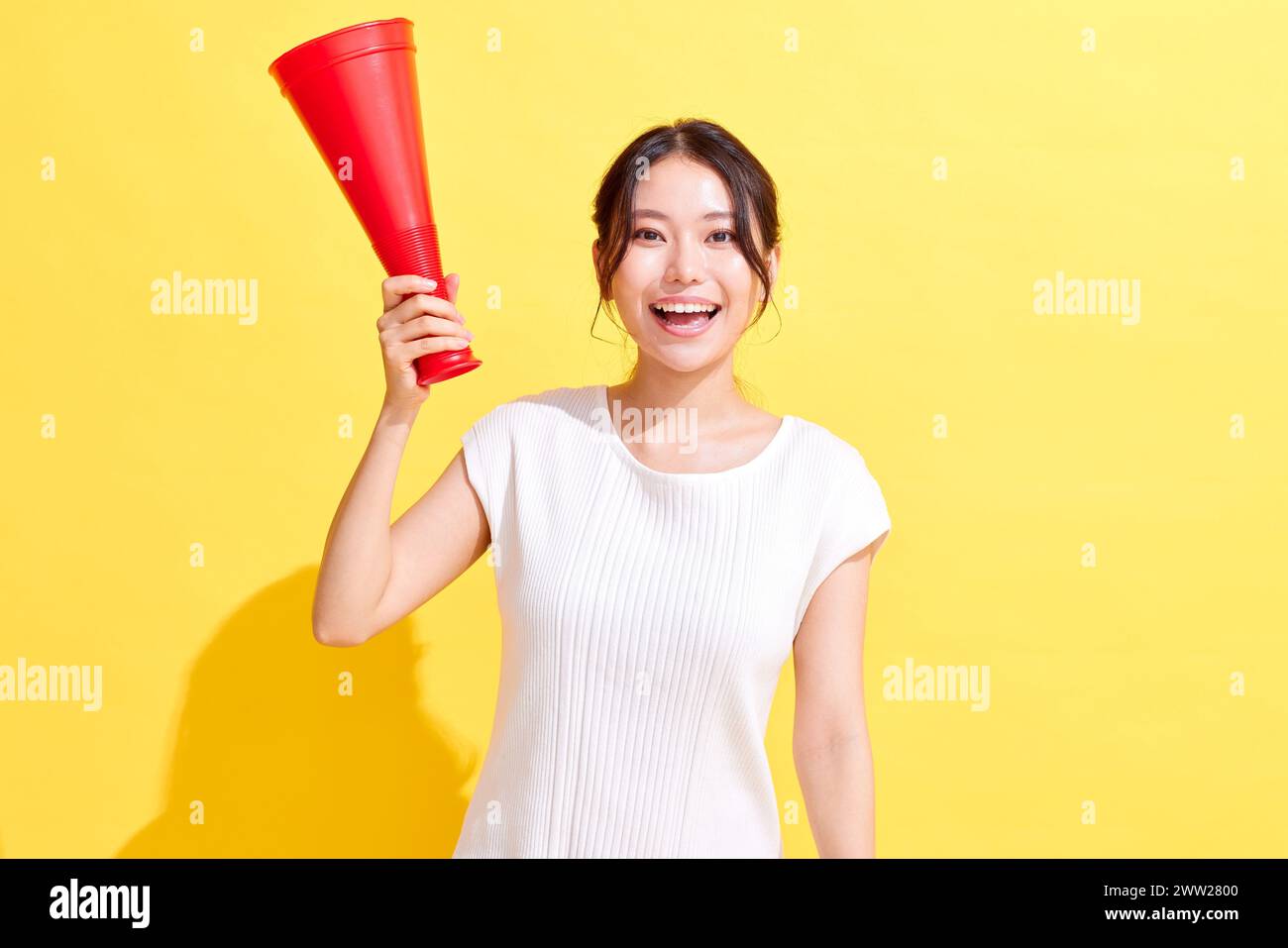 Donna asiatica con un megafono rosso Foto Stock