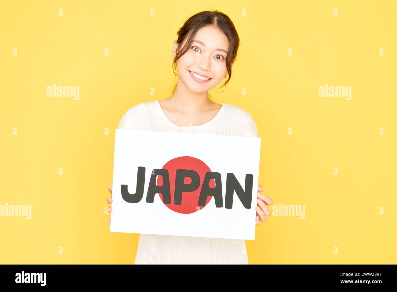 Una bella donna asiatica con un cartello con la parola Giappone Foto Stock
