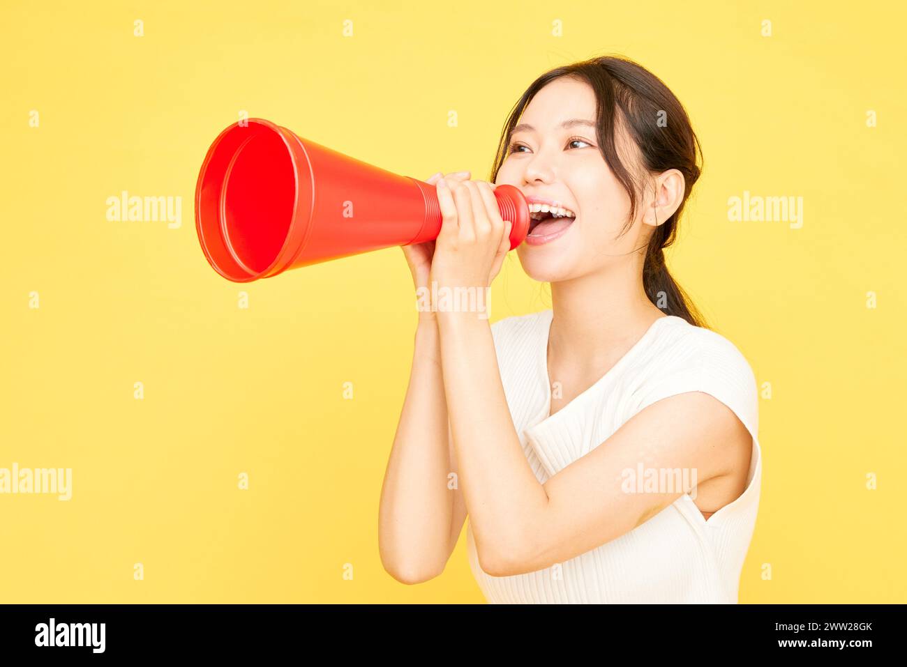 Donna asiatica che urla in un megafono Foto Stock