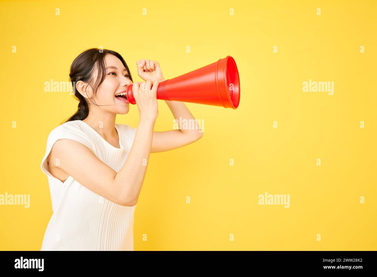 Una donna che urla in un megafono rosso Foto Stock