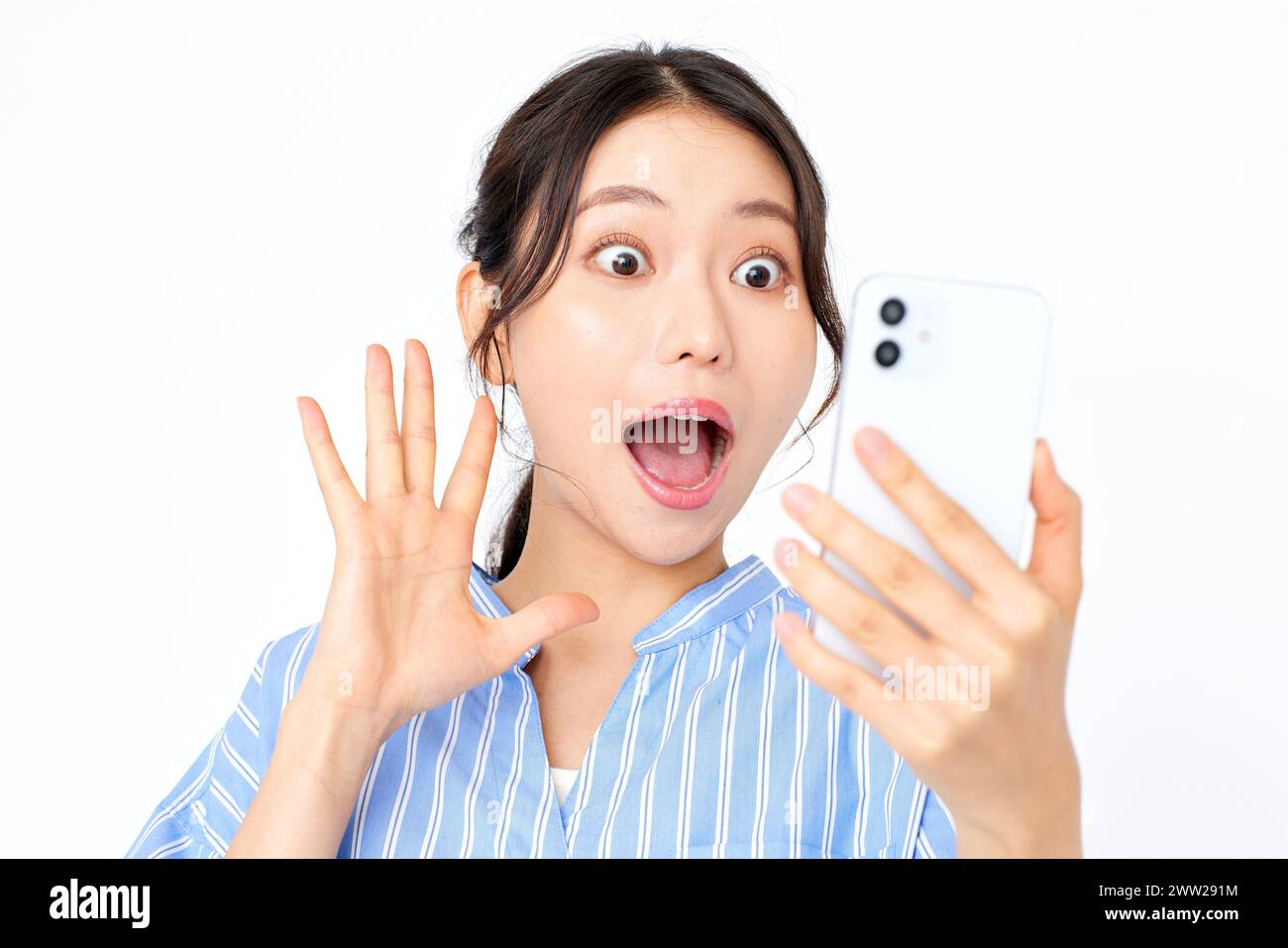 Una donna che tiene il telefono con la bocca aperta Foto Stock