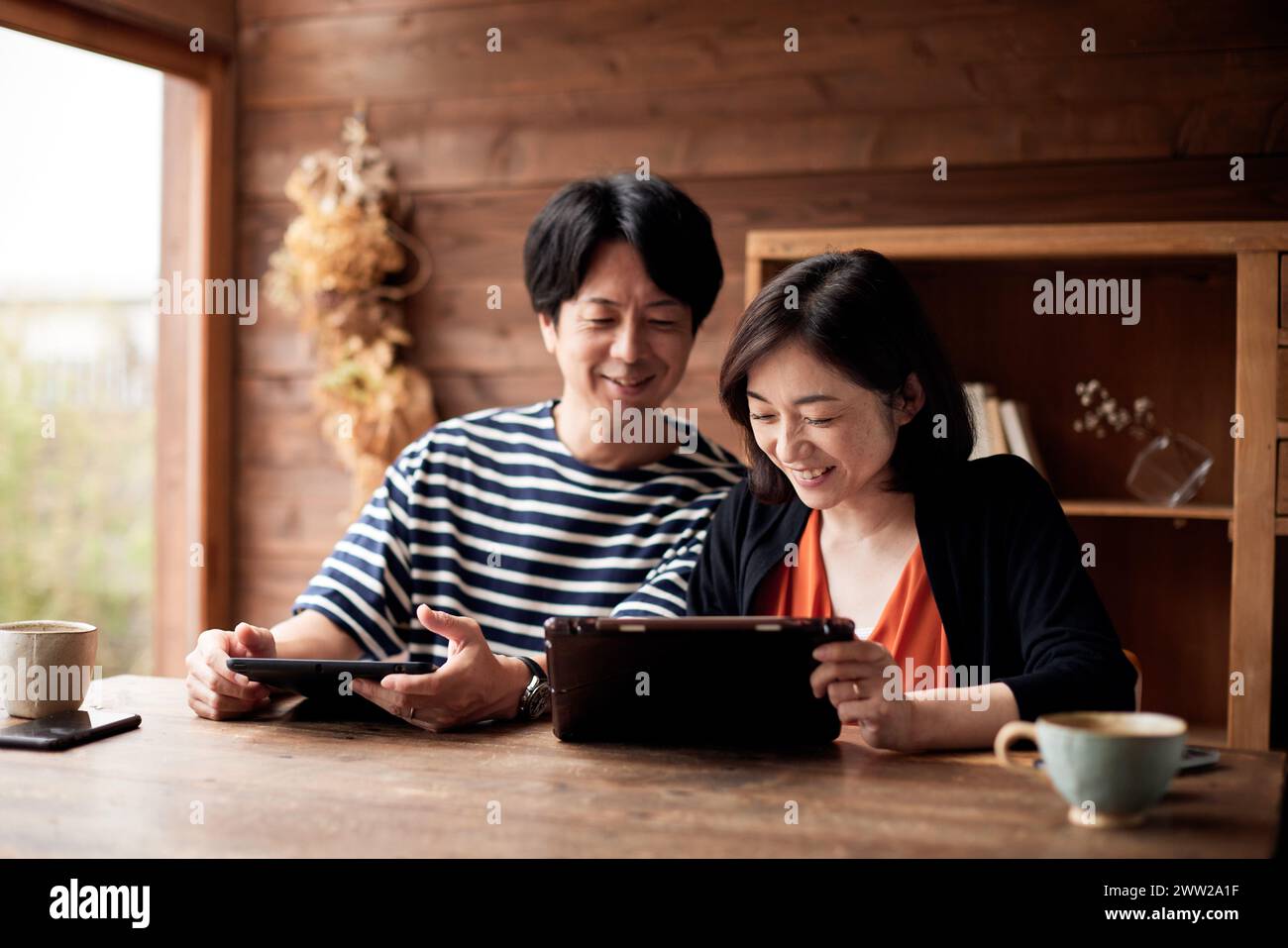 Coppia asiatica che usa un tablet a casa Foto Stock