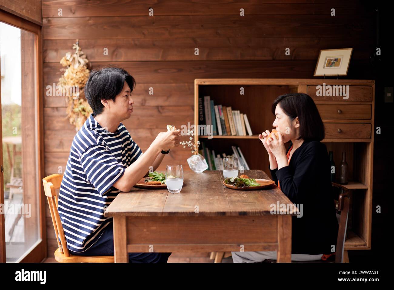 Un uomo e una donna seduti a un tavolo che mangiano cibo Foto Stock